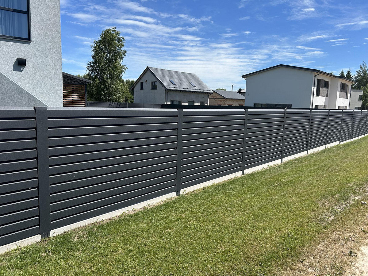Sumontuota modernios pilkos spalvos tvora prie privataus namo